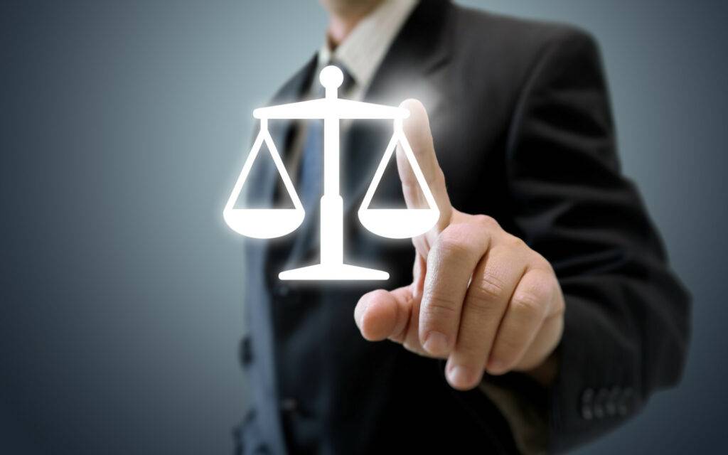 Forensic Accounting A businessman is pointing to the scales of justice in a criminal trial.